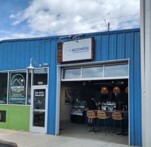 Photo provided by Moonrise Coffee Roasters, image of exterior building with open garage door entering into coffee shop.